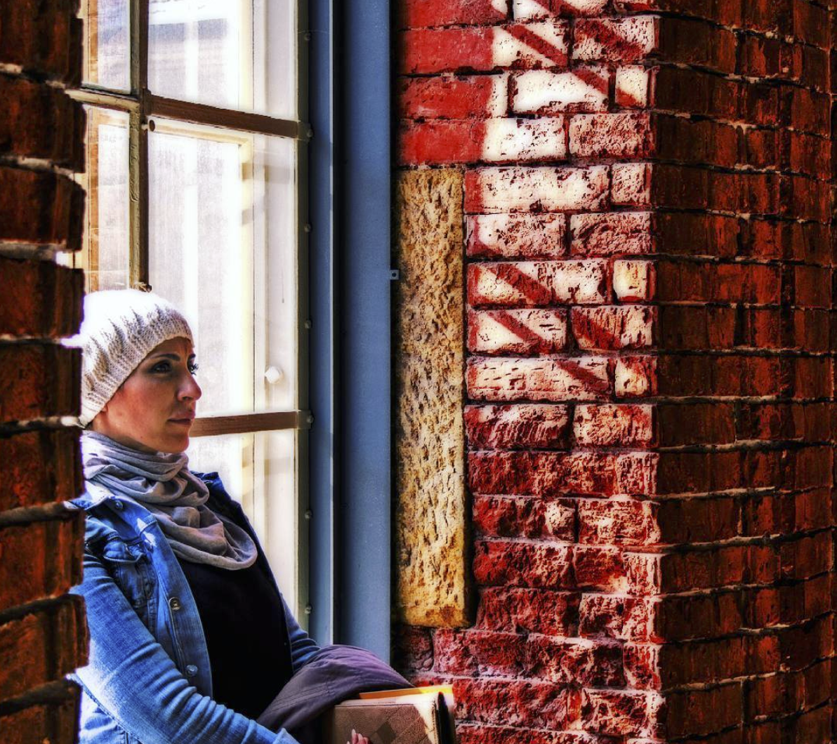 Woman in old building of dark red walls.