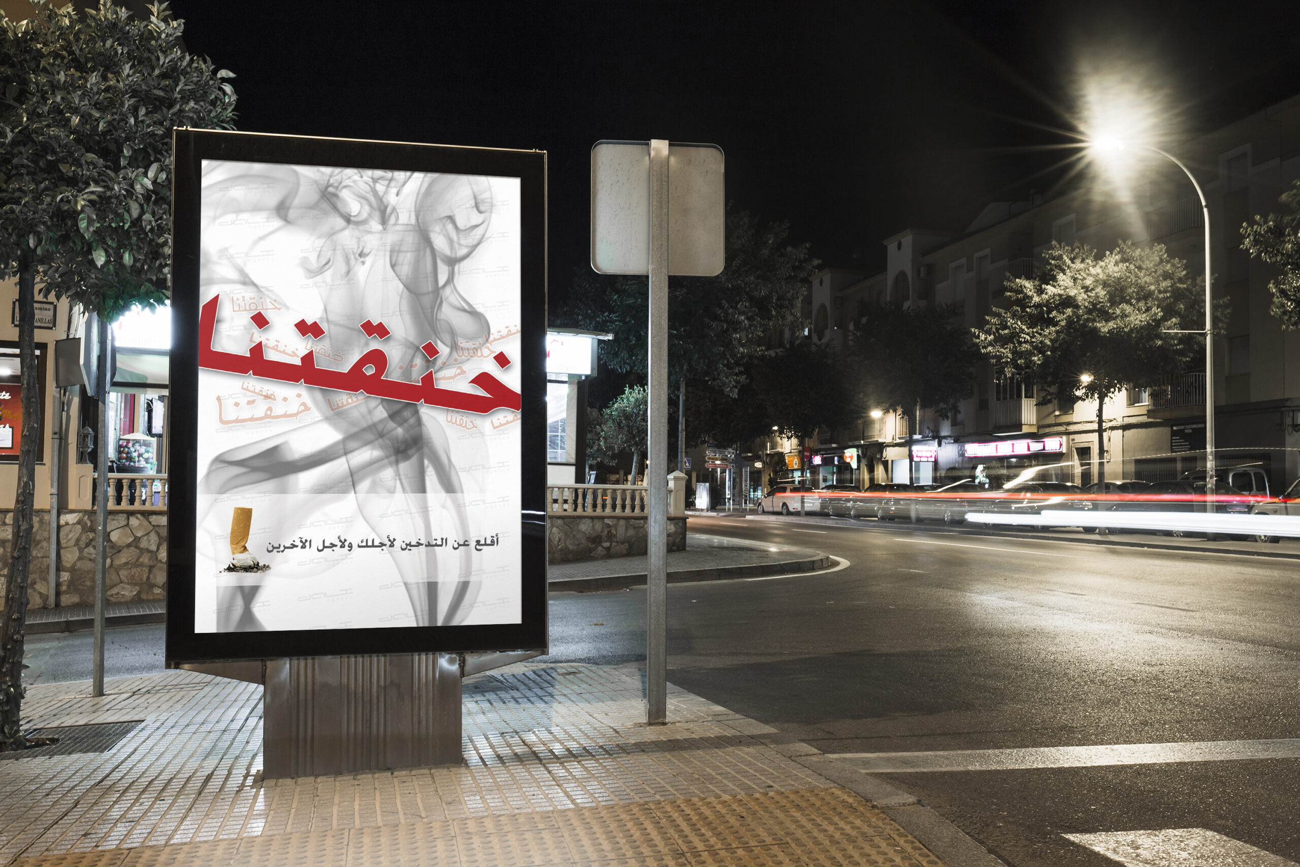 Street in the night with an outdoor poster at the corner.
